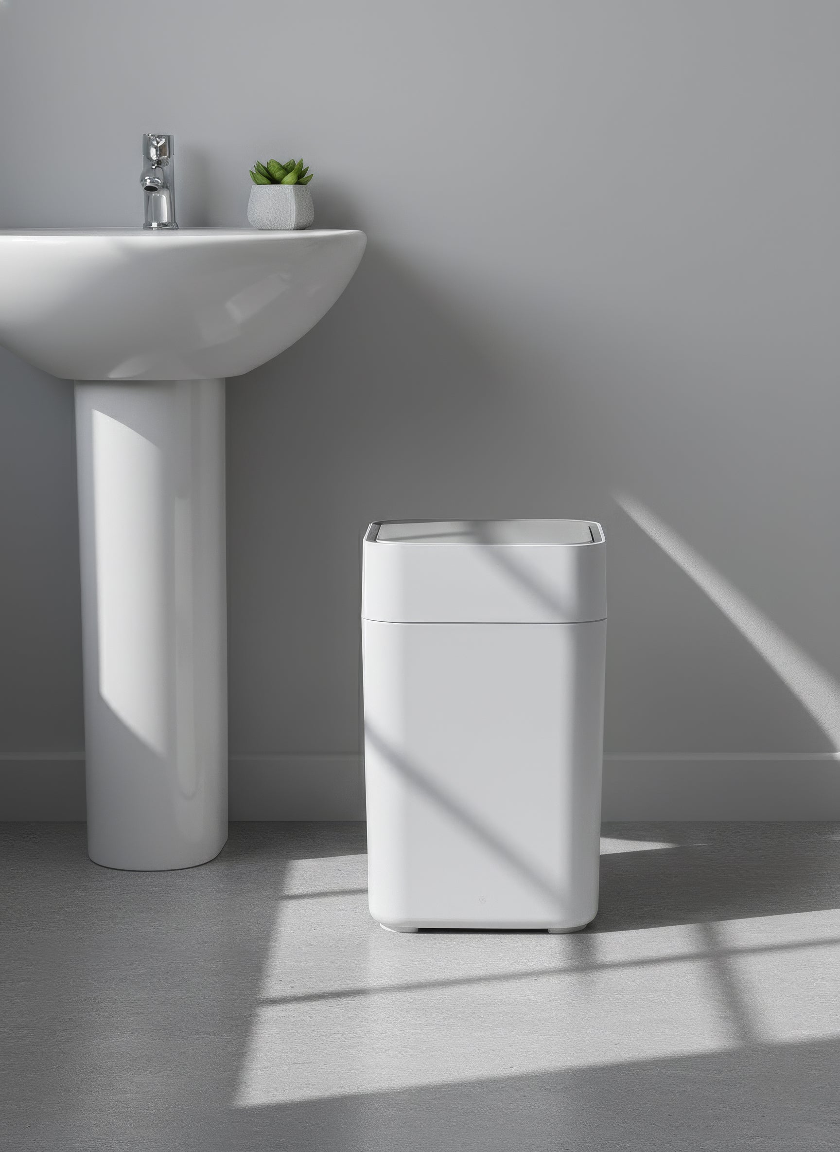 White trash bin next to a sink in a bathroom setting